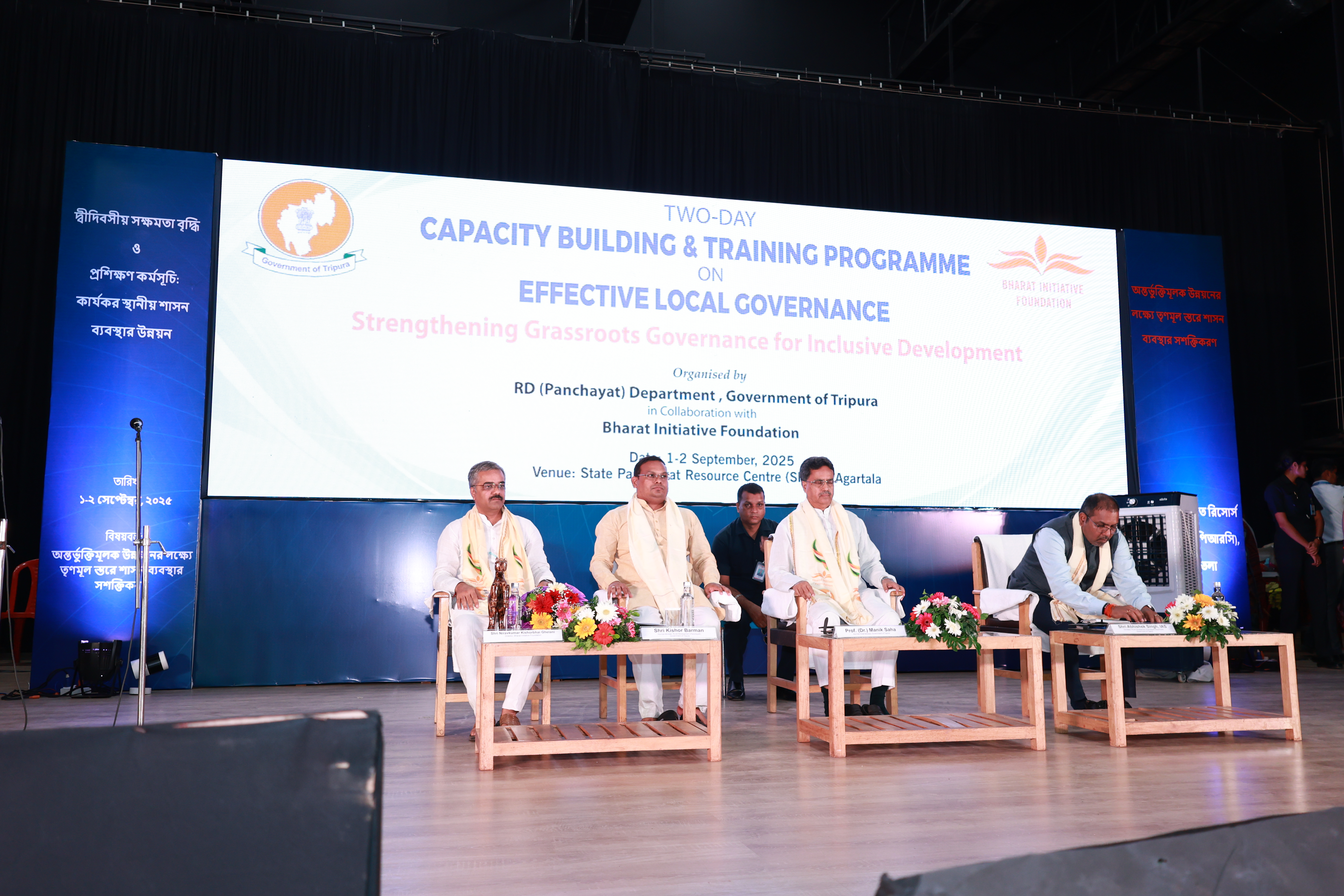 Guests seated across the stage in front of the programme banner