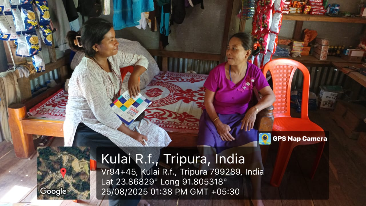 A field investigator speaking with a woman inside a household shop in Kulai