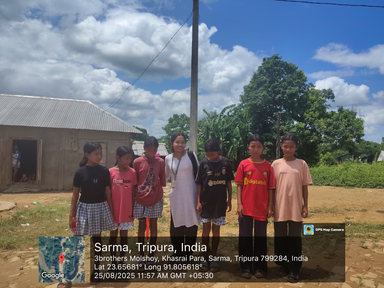 A field investigator standing with a group of children in Sarma, Khasrai Para