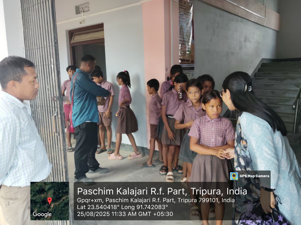 Field team members speaking with school students in uniform in Paschim Kalajari